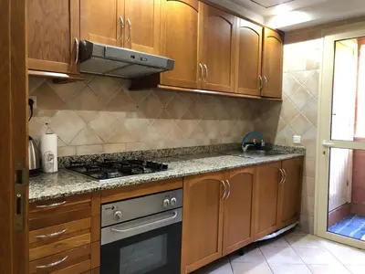 a kitchen with wooden cabinets and a stove top oven at MAJORELLE APPARTEMENT FAMILIAL in Marrakech