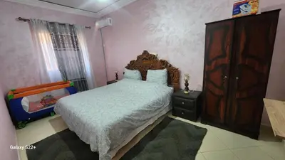 a bedroom with a bed and a wooden dresser at Appartement C à 7 min de l’aéroport de Marrakech in Marrakech