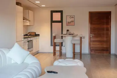 a living room with a white couch and a kitchen at Majestic Splendor - Marrakech Centre in Marrakech