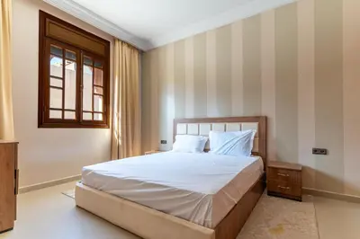a bedroom with a bed with white sheets and a window at Royal mirage villa(families only) in Marrakech