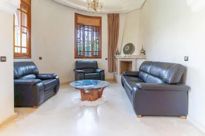 a living room with leather furniture and a table at Royal mirage villa(families only) in Marrakech