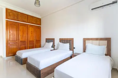 two beds in a room with white walls and wooden cabinets at Royal mirage villa(families only) in Marrakech