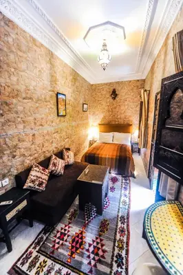 a bedroom with a bed and a couch in a room at Riad Errabii & Spa in Marrakech