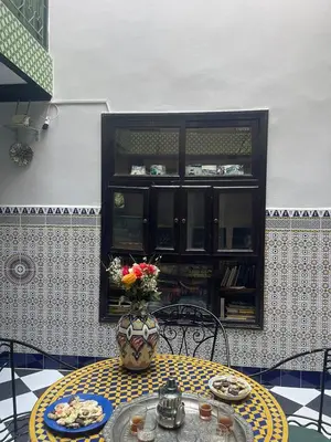 a table with a vase of flowers on it at HOTEL EL AMAL in Marrakech