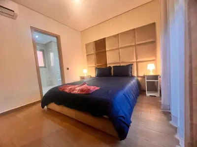 a bedroom with a large bed with a large window at Opale CITY GOLF Luxe Apart 3 Rooms in Marrakech