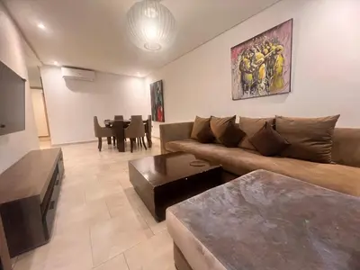 a living room with a couch and a table at Opale CITY GOLF Luxe Apart 3 Rooms in Marrakech