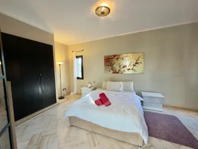 a bedroom with a white bed with a red bow on it at Sublime Villa Riad en ville avec piscine in Marrakech