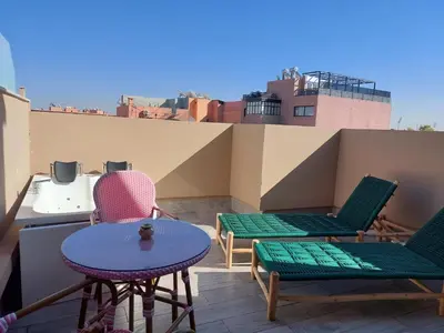 a patio with chairs and a table on a roof at Swiss Continental Hôtel in Marrakech
