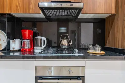 a kitchen with a stove top with a red appliance at Royal KING Bed SUITE W/POOL in Marrakech