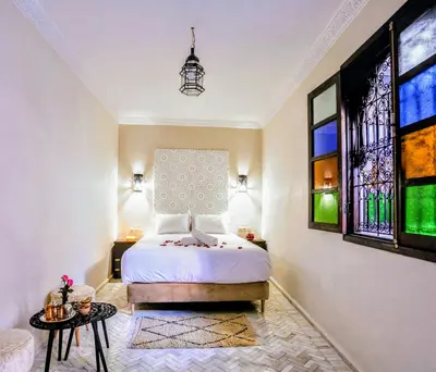 a bedroom with a bed and stained glass windows at Riad Zazz in Marrakech