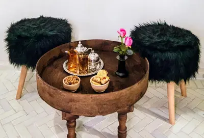 a table with a tea set on it with two tufted chairs at Riad Zazz in Marrakech