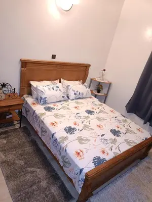 a bedroom with a bed with a floral bedspread at 1 Room only for women للنساء فقط in Marrakech