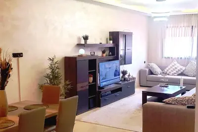 a living room with a large entertainment center with a television at appartement chic haut standing centre gare in Marrakech