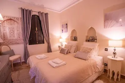 a bedroom with a bed with two towels on it at Dar Ines - Palmeraie, 250m2, pool, patio, terrace in Marrakech