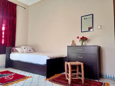 a bedroom with a bed and a dresser and a chair at Nahe Park Issil und Marjane. Yoga auf Anfrage. in Marrakech