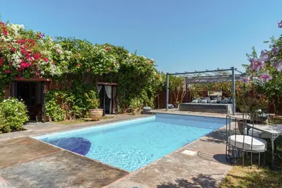 a swimming pool in a yard with flowers at Private Villa Comfort & Relax-Heated Pool in Marrakech