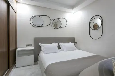 a white bedroom with two mirrors on the wall at African Dream - Marrakech Centre in Marrakech