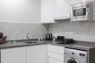 a kitchen with white cabinets and a microwave and a dishwasher at African Dream - Marrakech Centre in Marrakech