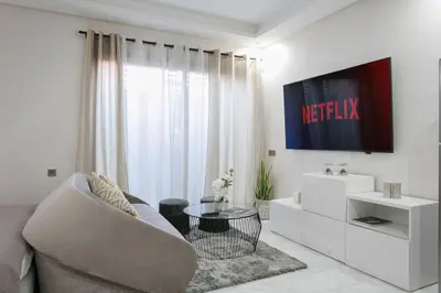 a white living room with a couch and a tv at African Dream - Marrakech Centre in Marrakech