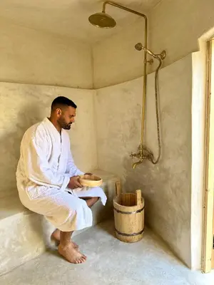 a man in a bath room with a shower at Riad le R - Riad privatif de luxe in Marrakech