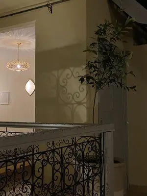 a staircase with a mirror and a plant on the wall at Riad le R - Riad privatif de luxe in Marrakech