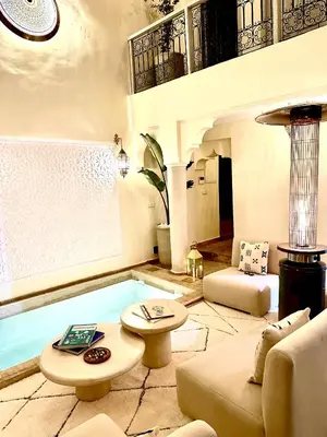 a living room with a pool in the middle of it at Riad le R - Riad privatif de luxe in Marrakech