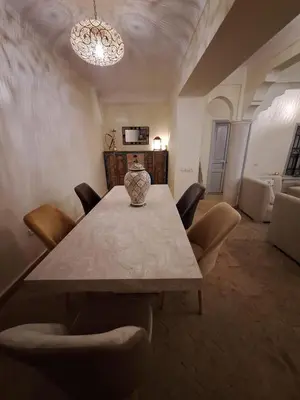 a dining room table with chairs and a vase on it at Riad le R - Riad privatif de luxe in Marrakech