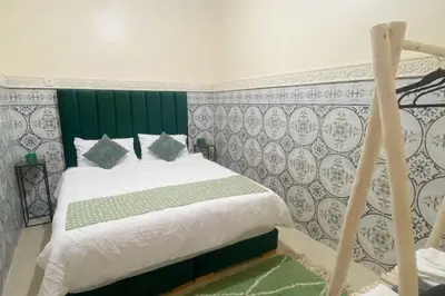 a bedroom with a bed with a green headboard at Medina House in Marrakech