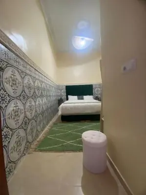 a room with a bed and a green carpet at Medina House in Marrakech