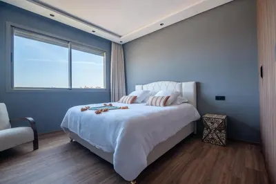 a bedroom with a large bed with a large window at Villa Saadia in Douar Bellouk