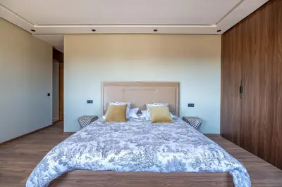 a bedroom with a large bed with yellow pillows at Villa Saadia in Douar Bellouk