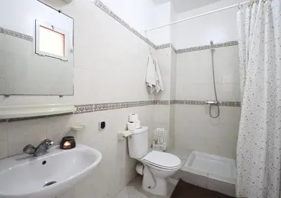 a white bathroom with a toilet and a sink at appartement confort calme propre WIFI in Marrakech