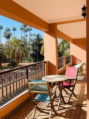 a patio with a table and chairs on a balcony at Appartement Résidence de standing Hivernage in Marrakech