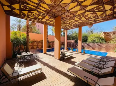 a patio with a bunch of chairs and a pool at Appartement Résidence de standing Hivernage in Marrakech