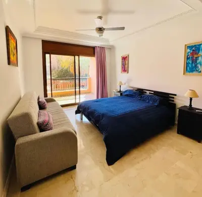 a bedroom with a bed and a couch and a window at Appartement Résidence de standing Hivernage in Marrakech