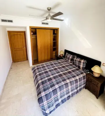 a bedroom with a bed and a ceiling fan at Appartement Résidence de standing Hivernage in Marrakech