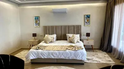 a bedroom with a large bed with two tables and two lamps at Palais FARAH in Marrakech