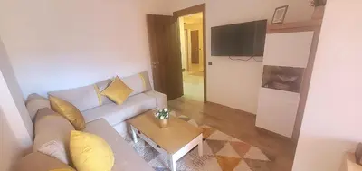 a living room with a couch and a table at Super appartement haut standing ensoleillé gare in Marrakech