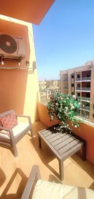 a balcony with a bench with a plant on it at Super appartement haut standing ensoleillé gare in Marrakech