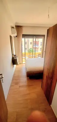 a bedroom with a bed and a large window at Super appartement haut standing ensoleillé gare in Marrakech