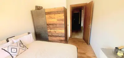 a bedroom with a bed and a wooden door at Super appartement haut standing ensoleillé gare in Marrakech