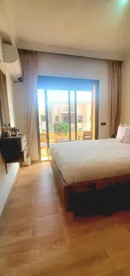 a bedroom with a large bed and a balcony at Super appartement haut standing ensoleillé gare in Marrakech