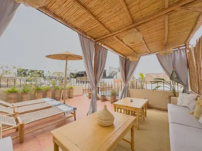 an outdoor living room with tables and chairs at Riad & SPA Privé - La Perle d'Orane - Marrakech in Marrakech