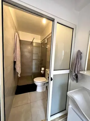 a bathroom with a toilet and a glass shower door at Cozy Apartment In Marrakech in Marrakech