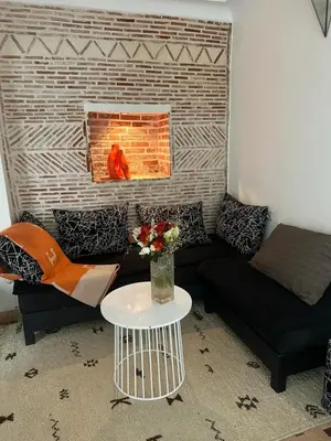 a living room with a couch and a fireplace at Riad Les Jardins de Kenza, idéalement situé, 5 minutes de la place Jemaa El Fna in Marrakech