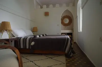 a bedroom with a bed with a black and white blanket at Riad Les Jardins de Kenza, idéalement situé, 5 minutes de la place Jemaa El Fna in Marrakech