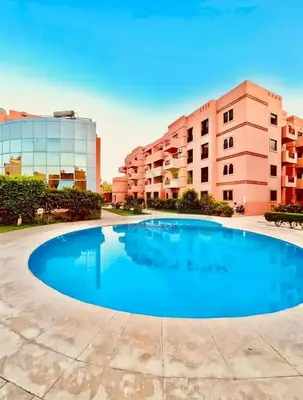 a large swimming pool in front of a building at Family Illuminated Apartment With Pool in Marrakech