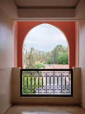 an arched window in a building with a balcony at Family Illuminated Apartment With Pool in Marrakech