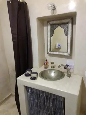 a bathroom with a sink and a mirror at Riad Bouganville Bleu in Marrakech