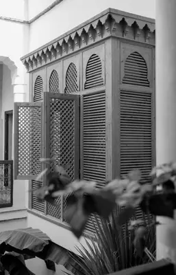 a window with wooden shutters on a building at Riad Le Sable Vert in Marrakech